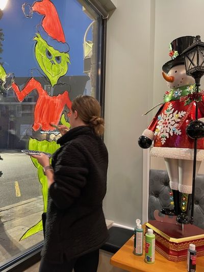 Our resident artist Grinches up the front window before the Holiday Stroll.